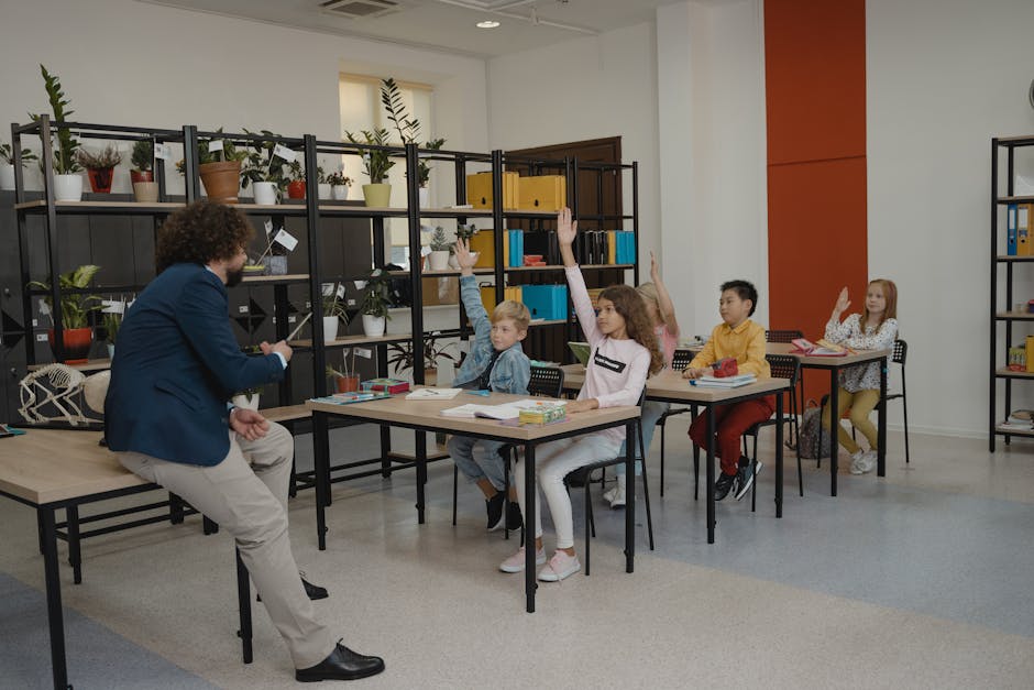 Students actively participating by raising hands in a modern classroom.